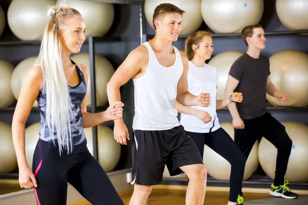 Cvičení motivované skupina skočí na platformy v posilovně fitness — Stock fotografie
