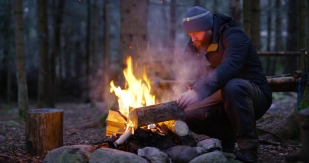 Дорослий чоловік підпалює багаття на вулиці в лісі — стокове відео