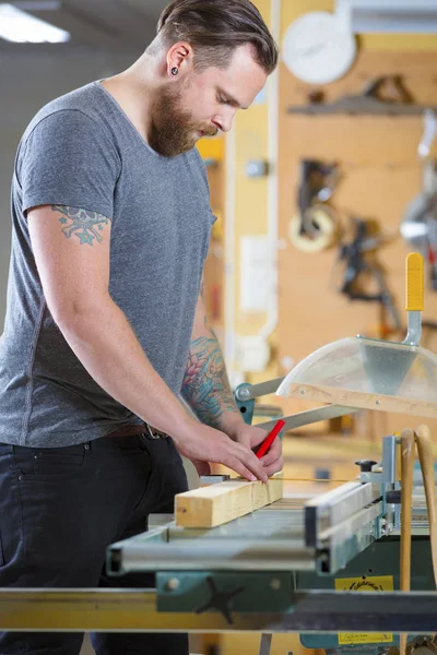 Timmerman maatregel de lengte van een houten plank vóór zagen — Stockfoto