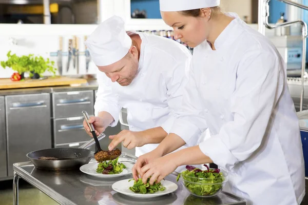 Két szakácsok készít steak étel ínyenc étteremben — Stock Fotó