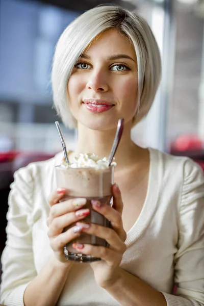 Femme tenant verre de chocolat chaud avec crème dans le café — Photo