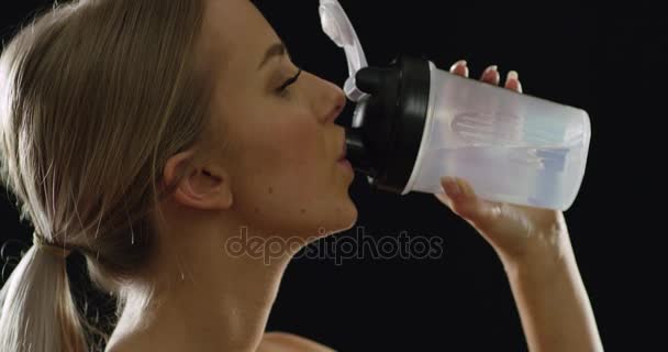 Ajuste y deportivo mujer rubia en equipo de entrenamiento agua potable — Vídeo de stock