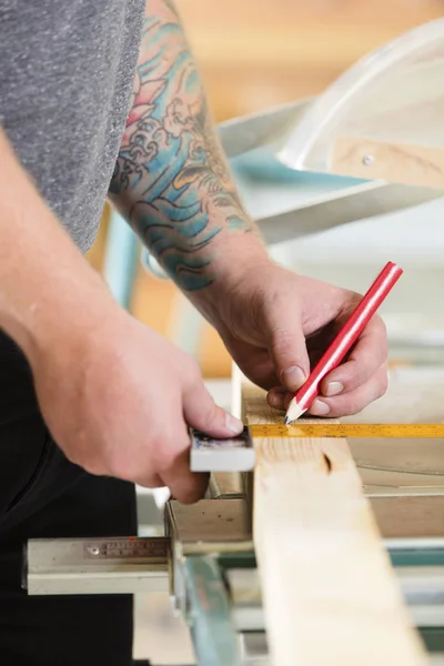 Timmerman maatregelen lengte een houten plank vóór zagen — Stockfoto