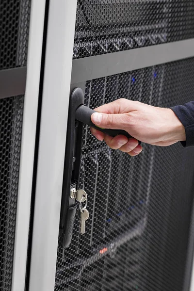 Ingegnere informatico apre porta a porta server rack in datacenter — Foto Stock