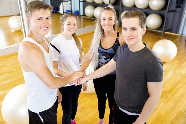 Primer plano del alegre equipo de entrenamiento de fitness cogido de la mano — Foto de Stock