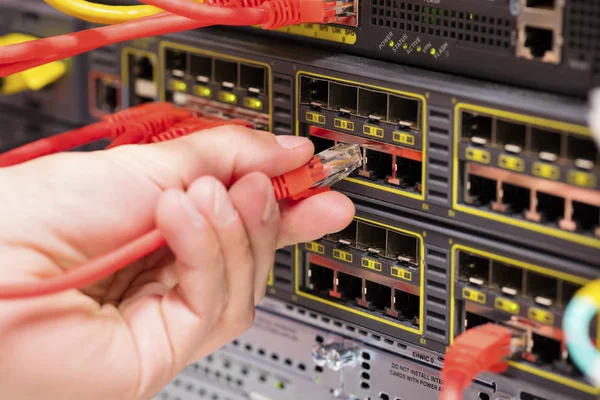 Consulente IT collega un cavo di rete in switch in datacenter — Foto Stock