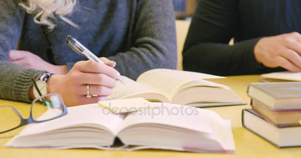 Close-up of two students team working in school library — Stock Video