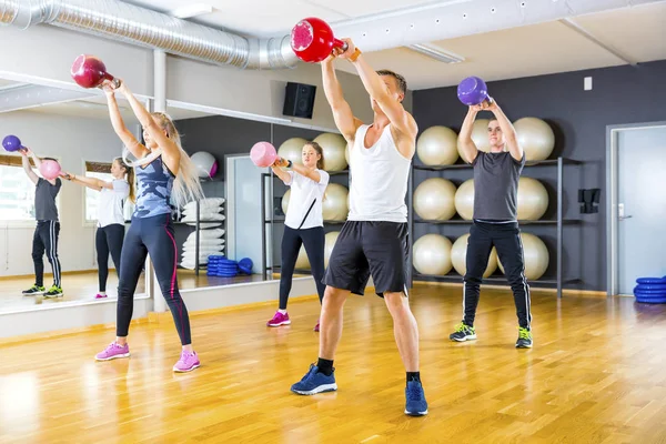 Fokuserat team tåg med kettlebells på gymmet fitness — Stockfoto