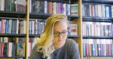 Okul kütüphanesinde çalışma gözlüklü kız öğrenci adanmış