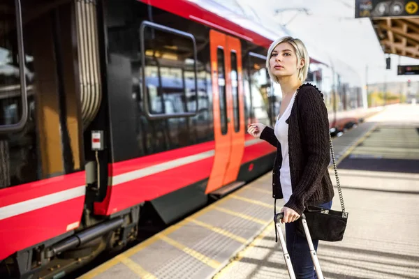 Mulher com bagagem em pé na estação ferroviária — Fotografia de Stock