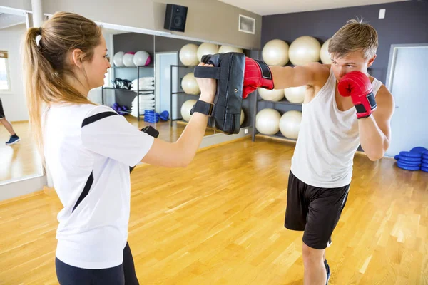 Boxeador saco de boxeo en poder del instructor en el gimnasio —  Fotos de Stock