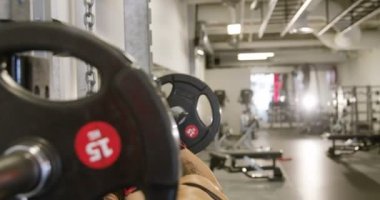 Gülümseyen kadın fitness salonunda ağır ağırlıklar ile ağız kavgası trenler