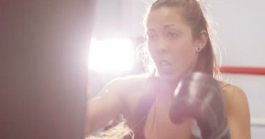 Güçlü kadın boksör kum torbası boks kulübünde çalıyor.