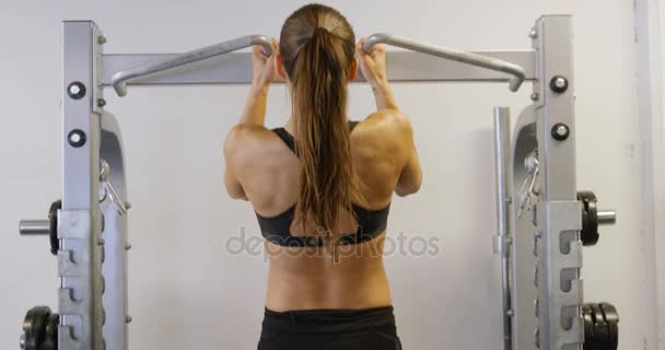 Mulher fitness de treinamento duro fazendo pull-ups pesados no ginásio de fitness — Vídeo de Stock