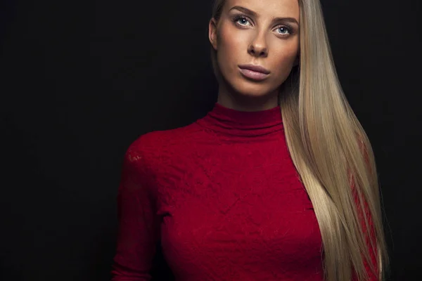 Dark portrait of a blonde woman in red dress — Stock Photo, Image