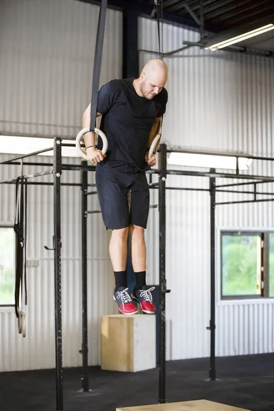 Erkek atlet jimnastik kullanarak sağlık kulübünde yüzük tespit — Stok fotoğraf