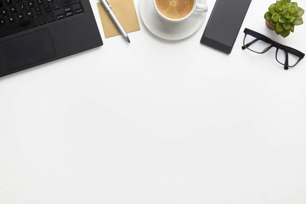 Laptop z filiżanka kawy, okulary i Smartphone na biały biurko — Zdjęcie stockowe