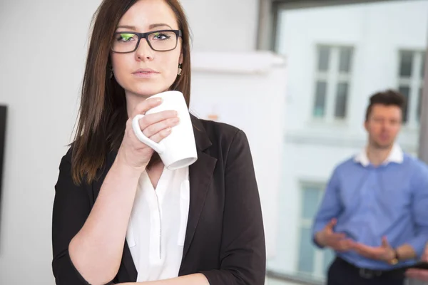 Femme d'affaires tenant tasse de café tandis que collègue debout dans Bac — Photo