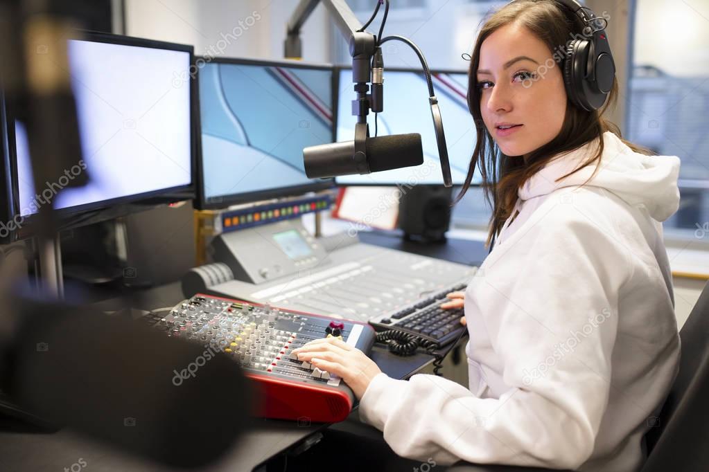 Portrait Of Jockey Using Headphones And Microphone In Radio Studio