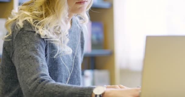 Detail zaměřené samice student pracuje ve školní knihovně — Stock video