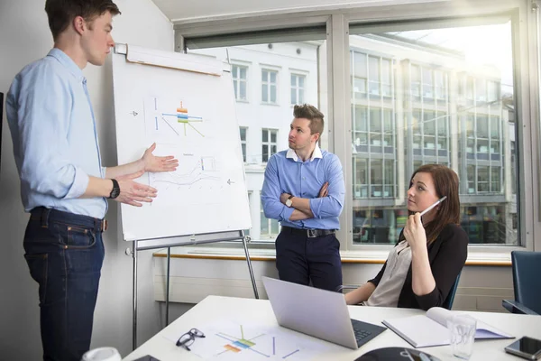 Young Businessman Explaining Chart To Male And Female Coworkers — Stock Photo, Image