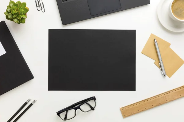 Pohled shora na moderní bílý kancelářský stůl s černým papírem v centru — Stock fotografie