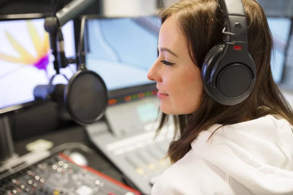 Θηλυκό κεντρικού υπολογιστή φορώντας ακουστικά στο ραδιοφωνικό στούντιο — Φωτογραφία Αρχείου