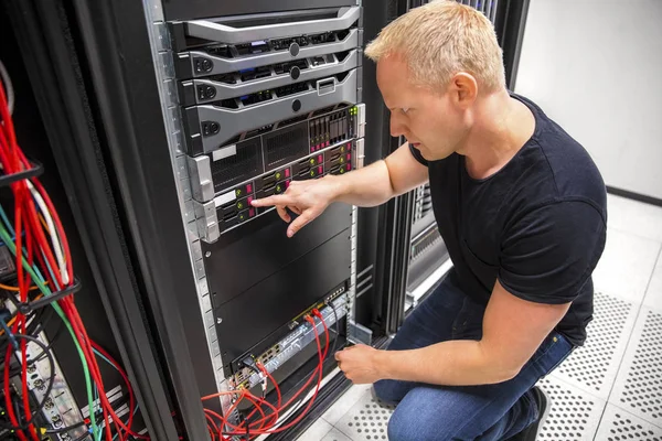 Technicien informatique surveille le serveur sur rack dans le centre de données — Photo