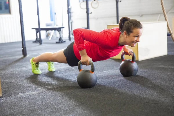 Determined Woman Doing Pushups On Kettlebell In Health Club — Stock Photo, Image