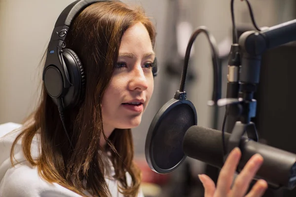 Jockey femenino hablando en micrófono en estudio de radio — Foto de Stock