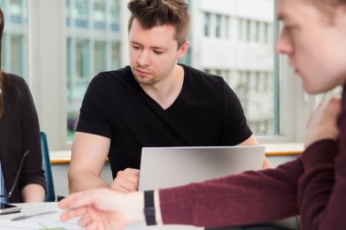 Laptop ve masada oturan arkadaşları ile işadamı
