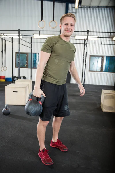 Confident Male Athlete Lifting Kettlebell In Health Club — Stock Photo, Image