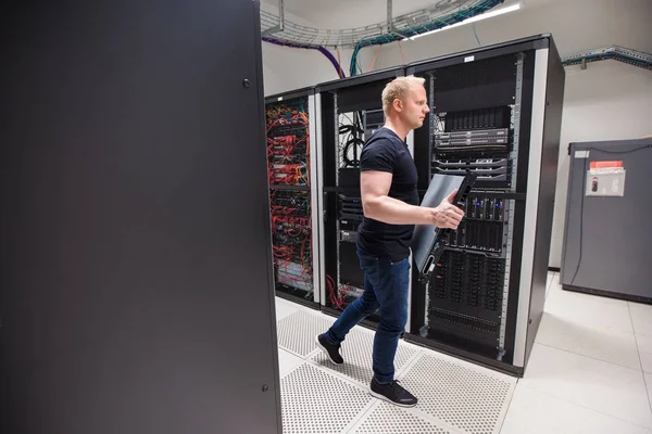 Männlicher Techniker trägt Blade Server, während er in Datacente geht — Stockfoto