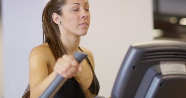 Entrenamiento de mujer saludable en la máquina de ejercicios de elipse en el gimnasio de fitness — Vídeos de Stock