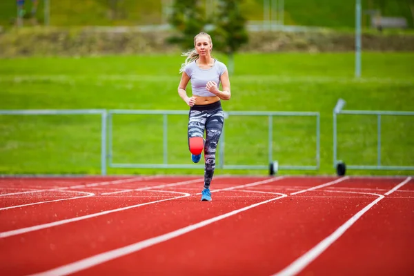 Jovem Feminino em Sportswear correndo em pistas de esportes — Fotografia de Stock