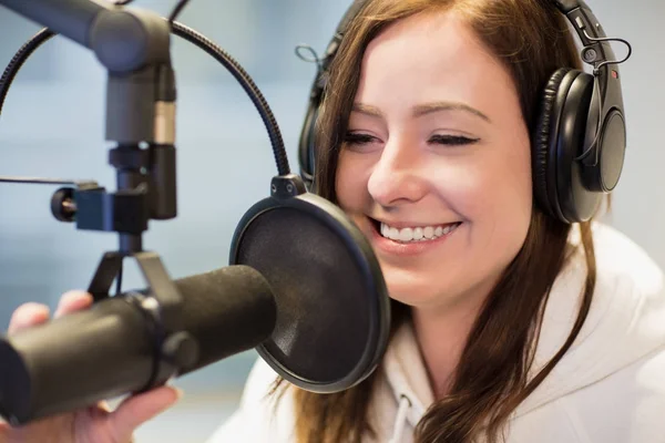 Žokej, usmíval se při používání sluchátek a mikrofonu v St Radio — Stock fotografie