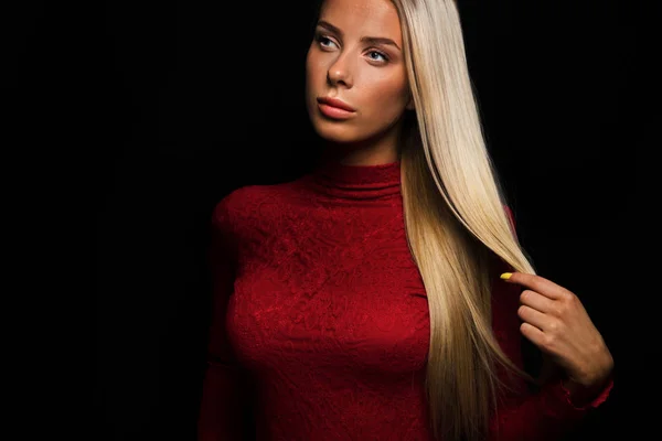 Dark portrait of a beautiful blonde woman in red dress with black bakground — Stock Photo, Image