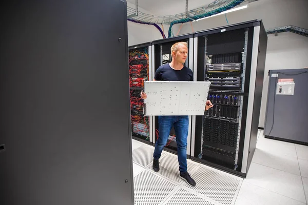 Consultant en TI portant le serveur de lame tout en marchant dans le datacenter — Photo