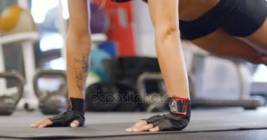 İyi eğitimli kadın gönderme yapıyor yakın çekim ups spor salonunda egzersiz minderi