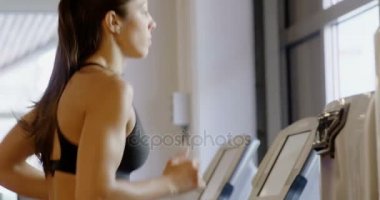 Fitness salonunda koşu bandı makinesinde çalışan uygun kadın Close-Up