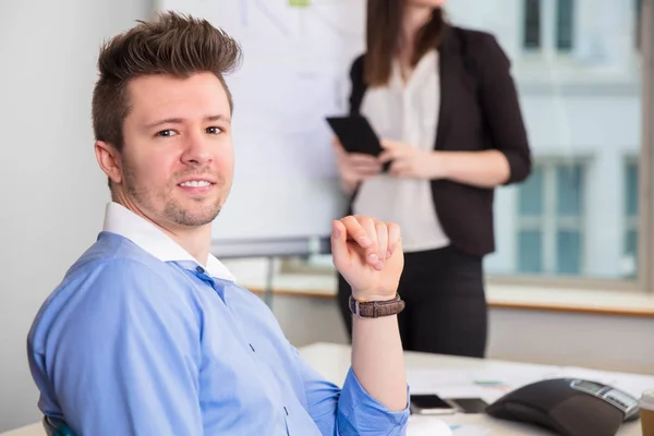 Homme d'affaires confiant souriant alors que son collègue est debout au bureau — Photo