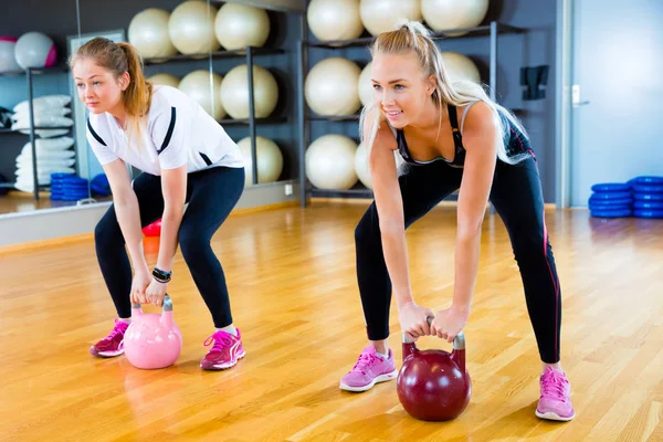 Determined Friends Lifting Kettlebells In Fitness Center — Stock Photo, Image