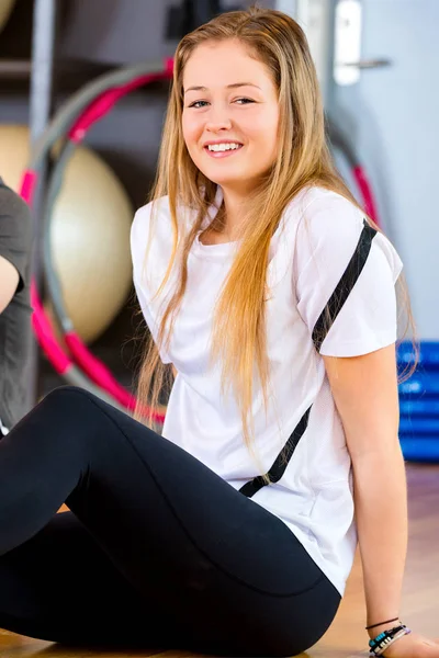 Primer plano del retrato sonriente de una mujer en reposo en el gimnasio — Foto de Stock