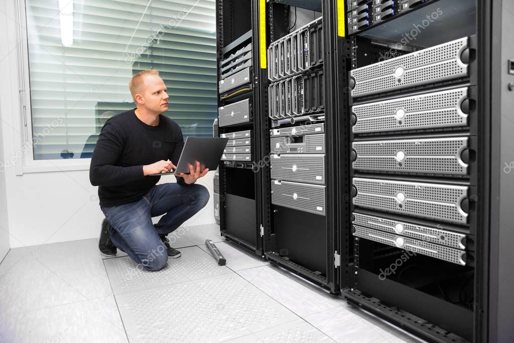 Consultant Using Laptop While Monitoring Servers In Datacenter