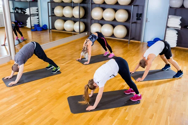 Vykonávání těla flexibilitu a rovnováhy na fitness tělocvičně skupiny — Stock fotografie