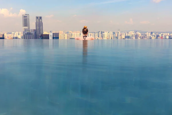 Mujer mirando paisaje urbano mientras se relaja en piscina infinita —  Fotos de Stock