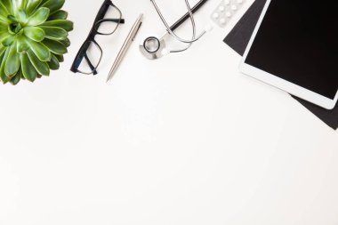 Stetoskop ve masada bitki tarafından gözlük ile dijital Tablet
