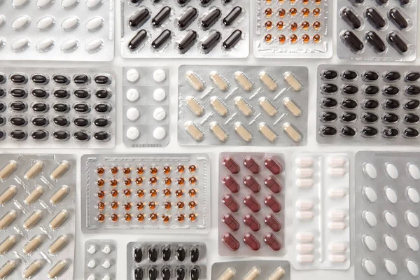 Vários comprimidos em embalagens de blister na mesa — Fotografia de Stock