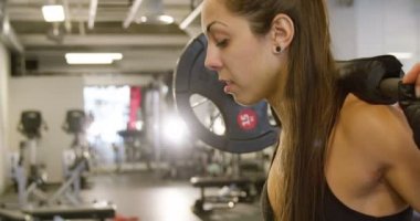 Fitness salonunda ağır ağırlıklar ile bir sportif kadın eğitim ağız kavgası Close-Up