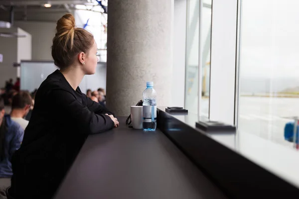 Resor kvinna väntar på flygplatsen och tittar ut genom fönstret — Stockfoto